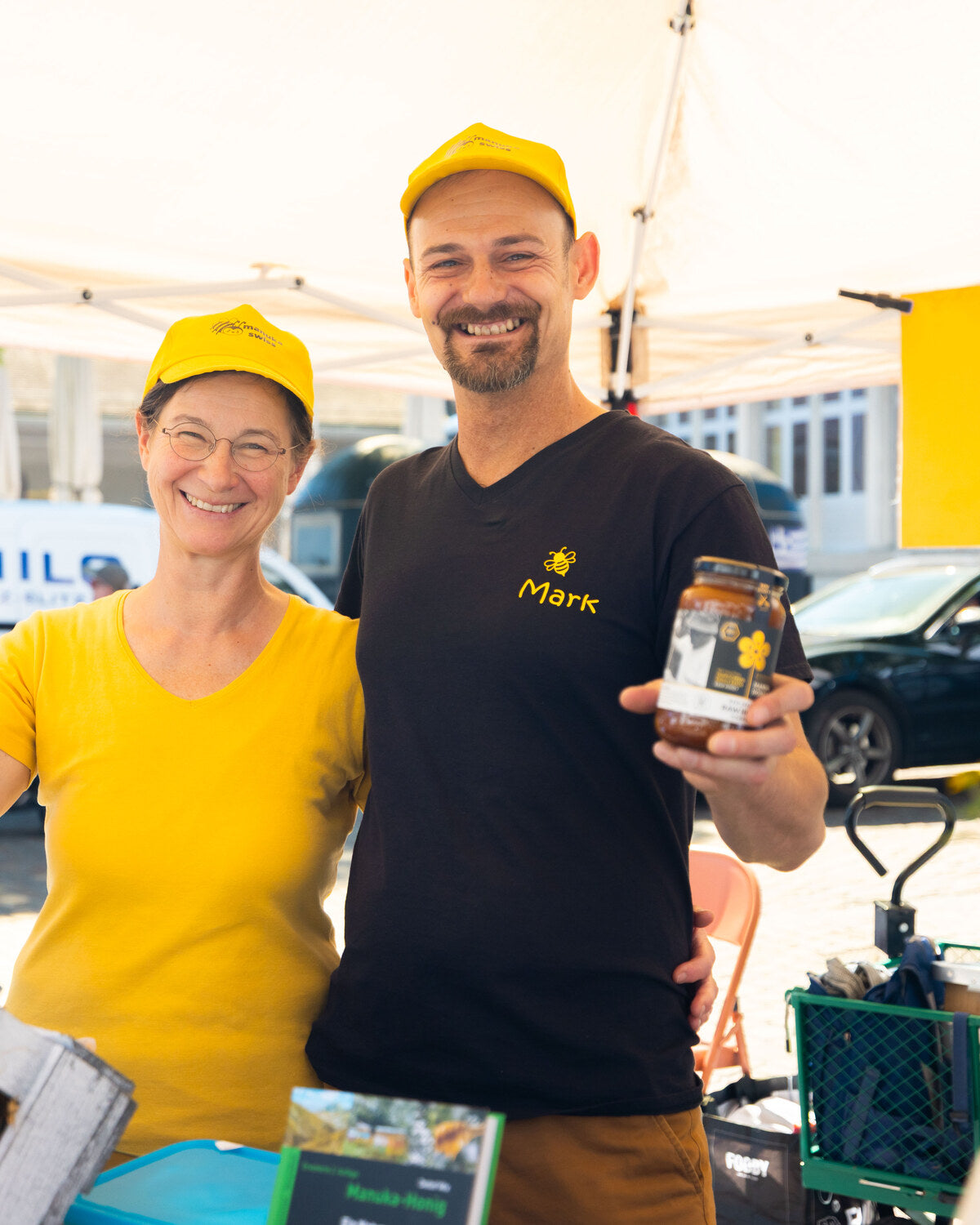 Mark und Adele Szabó am Marktstand von Manuka Swiss mit einem Glas Manuka-Honig